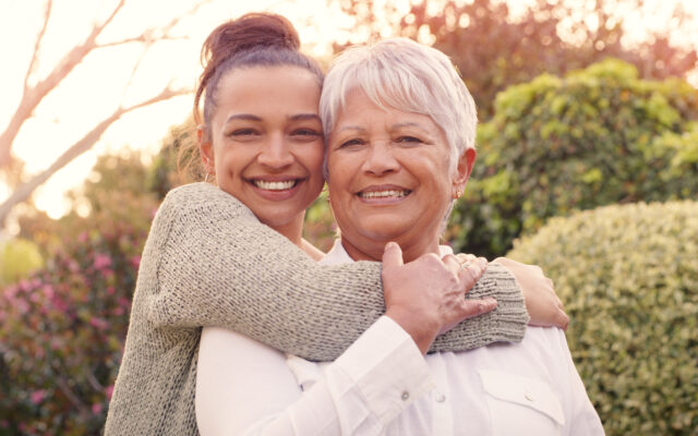 Shot of an attractive young woman standing outside with her arm around her mother