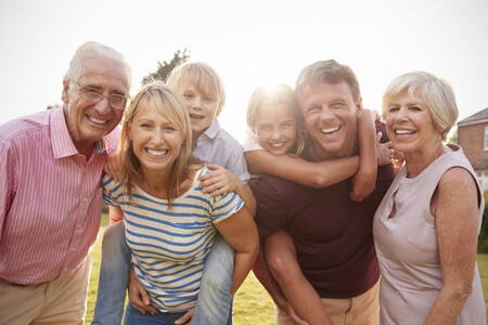 Multi generation family in garden smile to camera